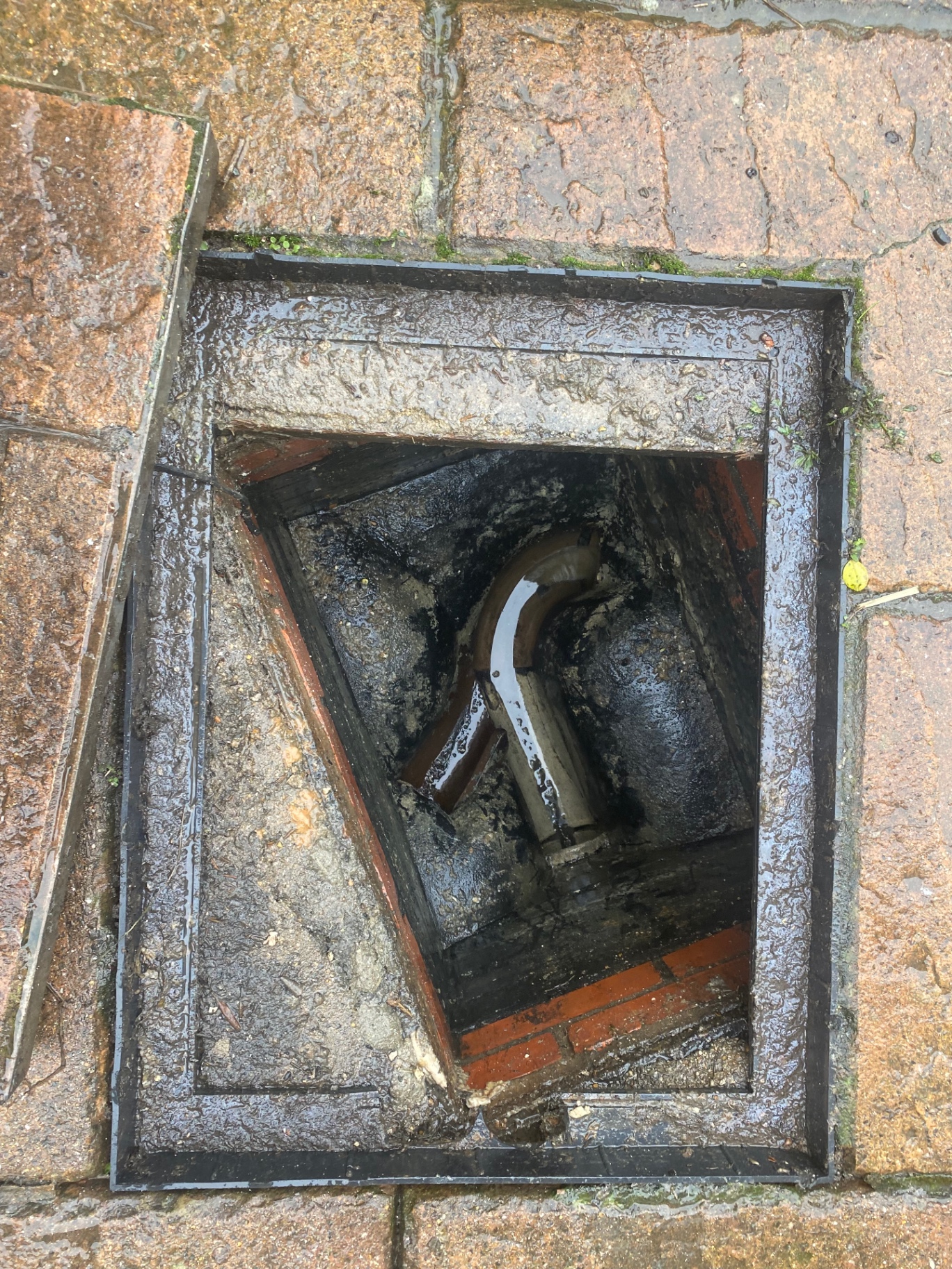 Brick-lined drain chamber in Hythe, Kent, emptied after unblocking to reveal the clay drainage pipes at the bottom, by First Response Drains